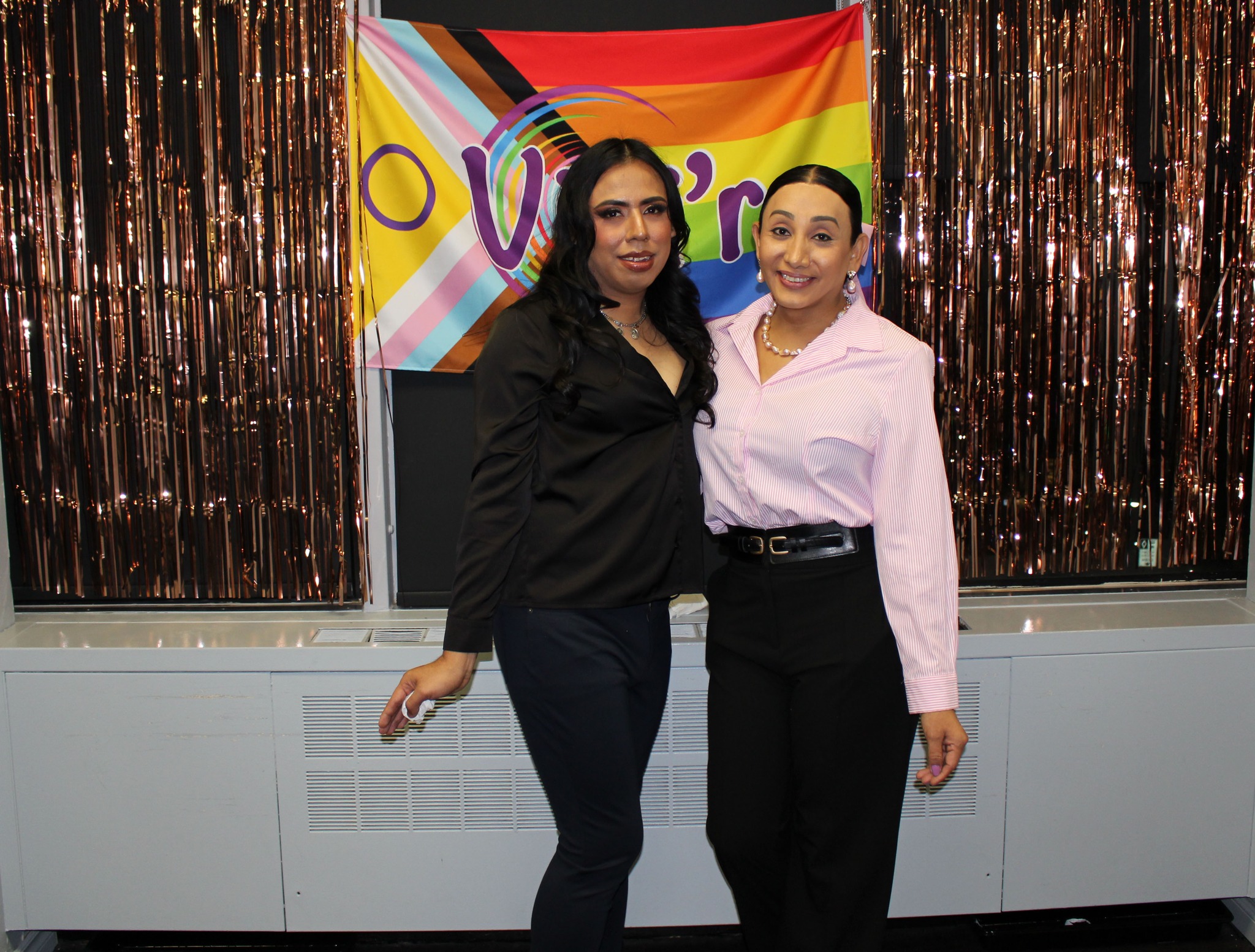 Two community members with the VIVI'R LGBTQ+ banner