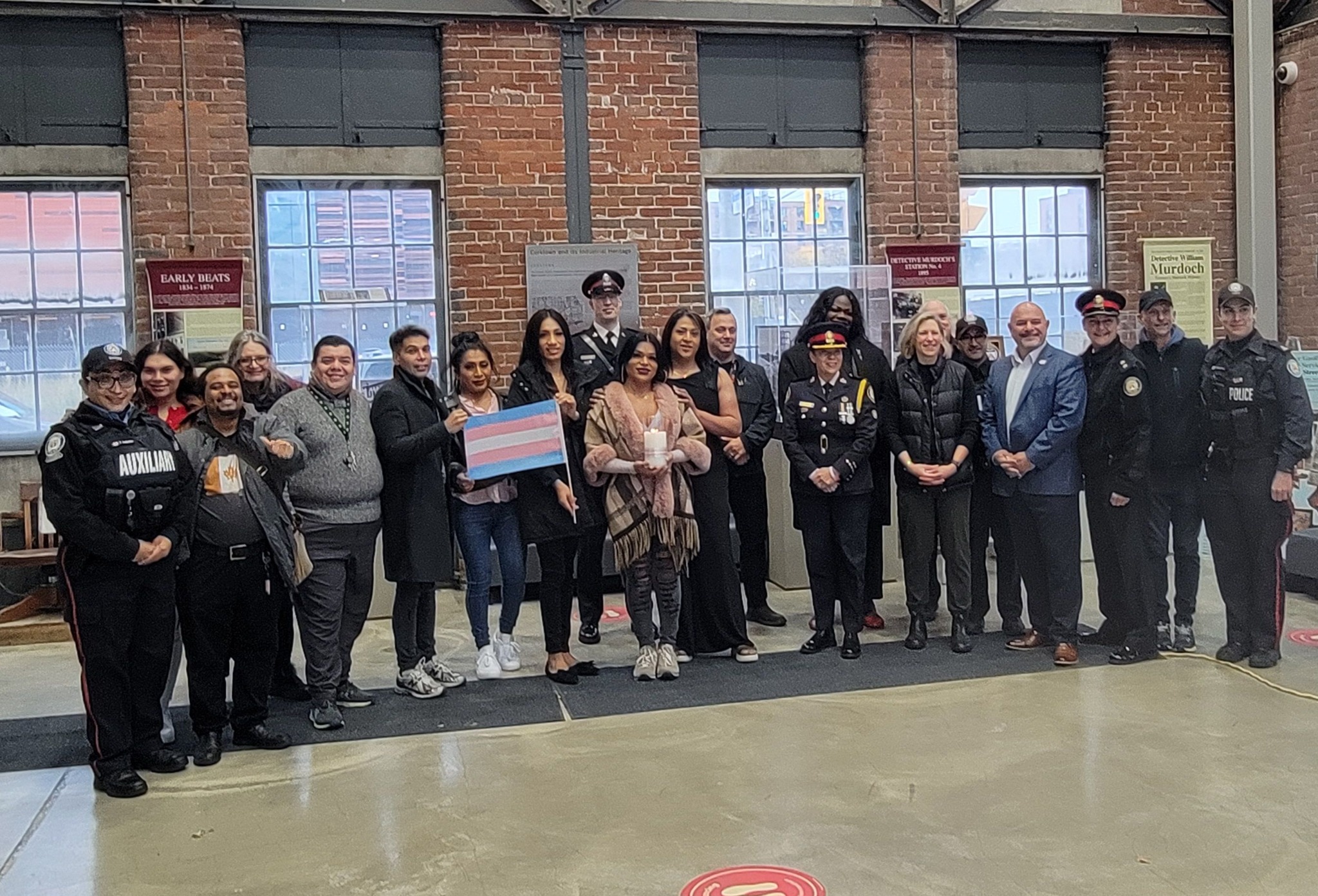 Group holding the trans flag at a museum