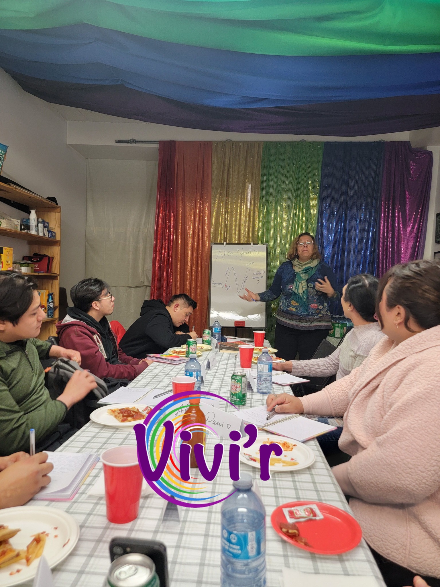 Workshop facilitator in front of a rainbow curtain
